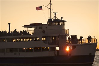 USA, New York City, Silhouette of passengers on tourboat.