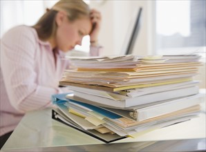 USA, New Jersey, Jersey City, Stressed young businesswoman doing paperwork. Photo : Jamie Grill