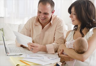 USA, New Jersey, Jersey City, Family with baby daughter (2-5 months) reading correspondence. Photo