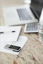 South Africa, Documents, laptop and mobile phone on desk, selective focus. Photo : momentimages