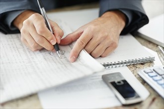 South Africa, Businessman doing paperwork, close-up. Photo : momentimages