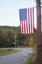 USA, New York State, Wurtsboro, American flag hanging on telephone pole. Photo : David Engelhardt