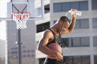 USA, Utah, Salt Lake City, basketball player pouring water on head. Photo : Mike Kemp