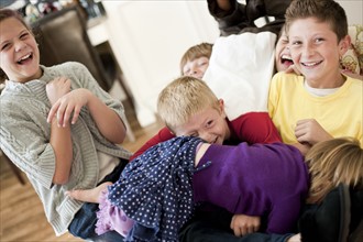 USA, Utah, Portrait of kids (2-3, 6-7, 10-11, 10-11) playing in living room. Photo : Tim Pannell