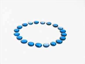 Studio shot of blue glass beads in circle. Photo : David Arky