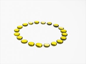 Studio shot of yellow glass beads in circle. Photo : David Arky