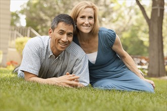 USA, Utah, Provo, Portrait of smiling mature couple sitting on lawn in garden. Photo : FBP