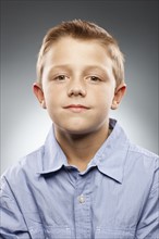 Portrait of boy (8-9) wearing shirt and looking at camera, studio shot. Photo : FBP