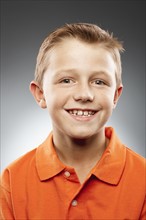 Portrait of boy (8-9) wearing polo shirt and looking at camera, studio shot. Photo : FBP