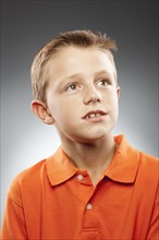 Portrait of boy (8-9) wearing polo shirt and looking away, studio shot. Photo : FBP
