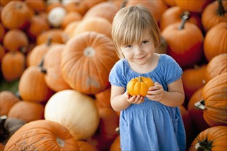 USA, Utah, Orem, portrait of girl (2-3) holding pumpkin. Photo : FBP