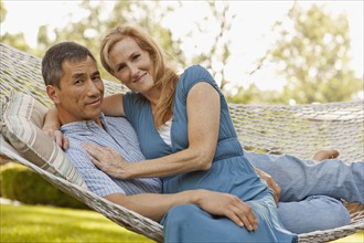 USA, Utah, Provo, Portrait of smiling mature couple relaxing in hammock in garden. Photo : FBP