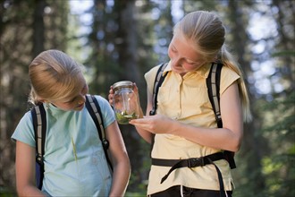 Canada, British Columbia, Fernie, two girls examining animal closed in jar. Photo : Dan Bannister