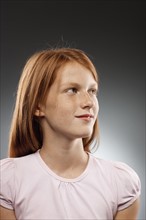 Portrait of redhead girl (10-11) looking away, studio shot. Photo : FBP