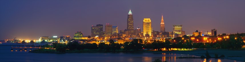 USA, Ohio, Cleveland, City skyline illuminated at dusk. Photo : Gary J Weathers