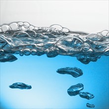 Close up of blue water surface with bubbles. Photo : David Arky