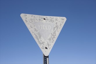 USA, Arizona, Winslow, Old yield sign against blue sky. Photo : David Engelhardt