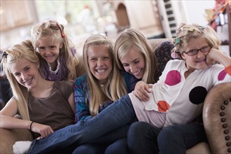 USA, Utah, family portrait of sisters on sofa (6-7, 8-9, 12-13, 14-15, 16-17). Photo : Tim Pannell