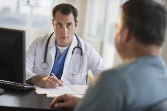 USA, New Jersey, Jersey City, Doctor discussing medical results with male patient in office.
