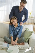 USA, New Jersey, Jersey City, Portrait of young couple relaxing on sofa.