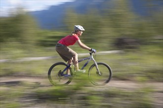 Canada, British Columbia, Fernie, Young woman riding on mountain bike. Photo : Dan Bannister
