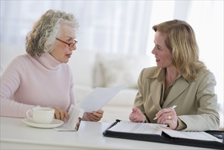 USA, New Jersey, Jersey City, Senior woman talking to financial advisor in home.
