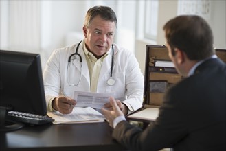 USA, New Jersey, Jersey City, Doctor discussing medical results with male patient in office.