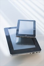 Two digital tablets reflecting light.