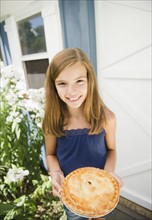 USA, New York, Girl (10-11) holding apple pie. Photo : Jamie Grill Photography