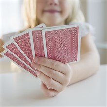 USA, New Jersey, Jersey City, Girl (8-9) playing cards. Photo : Jamie Grill Photography