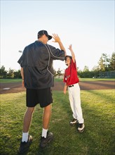 USA, California, Ladera Ranch, man and boy (10-11) on baseball field.