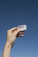 USA, Arizona, Winslow, Human hand holding paper with "hope" text on it. Photo : David Engelhardt