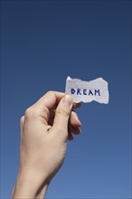 USA, Arizona, Winslow, Human hand holding paper with "dream" text on it. Photo : David Engelhardt