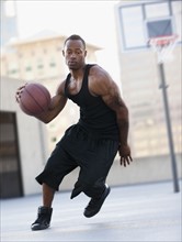 USA, Utah, Salt Lake City, young man playing basketball. Photo : Mike Kemp