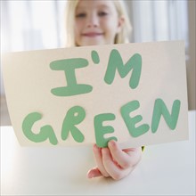 USA, New Jersey, Jersey City, Girl (8-9) holding "I'm green" board. Photo : Jamie Grill Photography