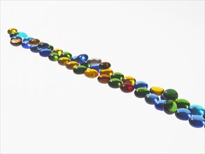 Studio shot of colorful glass beads in line. Photo : David Arky