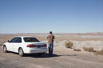 USA, Arizona, Painted Desert. Little Painted Desert, Man standing near car and looking at view.