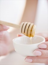 USA, New Jersey, Jersey City, Woman hand holding honey spoon. Photo : Jamie Grill Photography