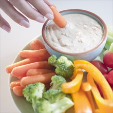 USA, New Jersey, Jersey City, Close-up view of woman hand putting baby carrot into dip. Photo :