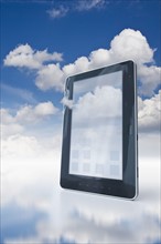 Digital tablet floating in clouds.