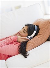 USA, New Jersey, Jersey City, Young attractive woman laying on back listening to music. Photo :