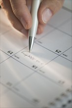 USA, New Jersey, Jersey City, Man writing on calendar.