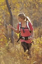 USA, Utah, young woman hiking in forest. Photo : Mike Kemp