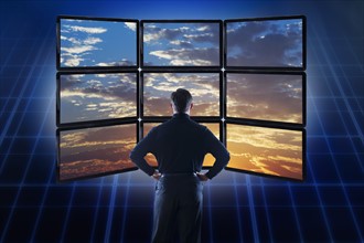 Businessman observing clouds on computer monitors.