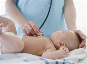 USA, New Jersey, Jersey City, Female doctor examining baby girl (2-5 months). Photo : Jamie Grill