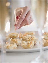 USA, New Jersey, Jersey City, Woman's hand sticking toothpick into fresh snack. Photo : Jamie Grill
