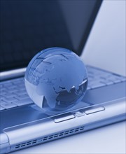 USA, New Jersey, Jersey City, Close-up view of blue laptop and globe. Photo : Daniel Grill