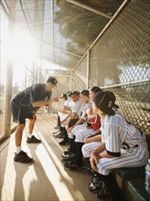 USA, California, Ladera Ranch, Boys (10-11) from little league sitting on dugout while coach