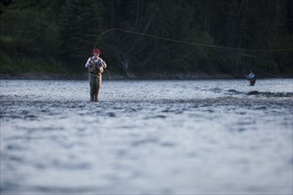 Canada, British Columbia, Fernie, Woman fly fishing in river. Photo : Dan Bannister