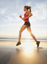 USA, California, Los Angeles, woman jogging on beach.